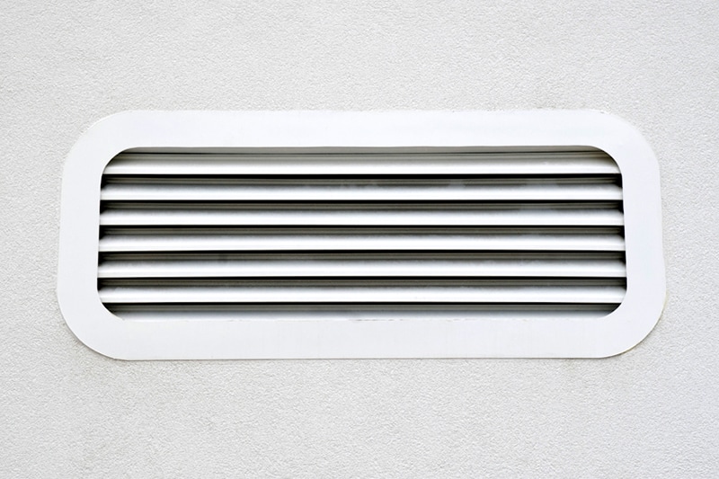 New white air conditioning vent on wall closeup
