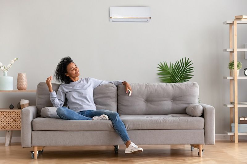What Accessories Can Help With My Indoor Air Quality? Image shows woman sitting on couch.