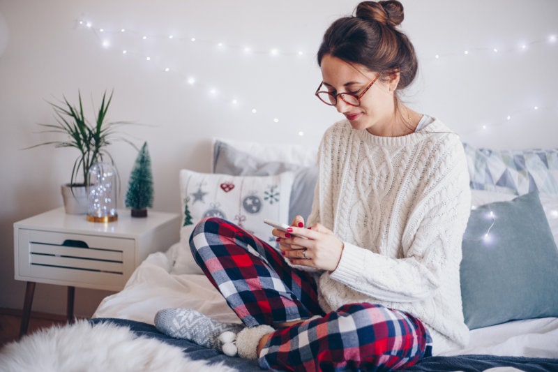 woman-texting-on-bed-winter
